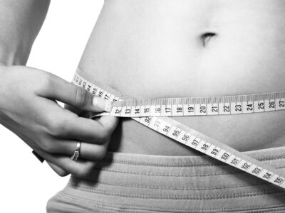 a woman measuring her waist